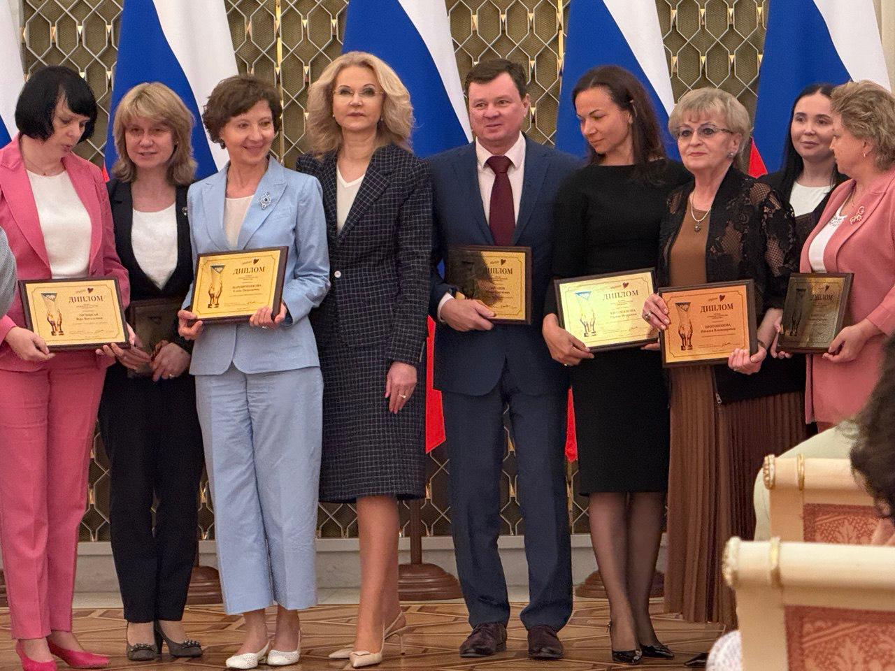 Врачи Иркутской областной клинической больницы – лауреаты премии «Призвание-2025» Команда врачей ИОКБ совместно с НМИЦ гематологии МЗ РФ под руководством Елены Паровичниковой удостоена главной медицинской премии России «Призвание-2025» в номинации «За создание нового направления в медицине». Дипломы премии из рук заместителя Председателя Правительства РФ Татьяны Голиковой получила заместитель главного врача по акушерско-гинекологической помощи ИОКБ Наталья Протопопова и заведующая гематологическим отделением ИОКБ Татьяна Капорская. Врачи разработали и успешно применяют метод лечения рака крови у беременных, не прерывая беременность. Методика лечения позволяет сохранить жизнь и матери, и ребенку. Ранее это считалось невозможным! «Лечение острого лейкоза, диагностированного во время беременности, является особенно трудной задачей. Такая тактика требует не только знаний многопрофильной команды врачей-специалистов, но и грамотного этического подхода», – отметила Наталья Протопопова. Этот прорыв стал возможен благодаря многолетней работе специалистов и следованию «стратегии спасения двух жизней». Поздравляем наших врачей с заслуженной наградой! Это признание высокого профессионализма и преданности делу!