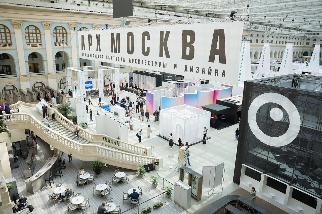 В этом году Арх Москва пригласила профессионалов архитектурно-строительной отрасли к разговору о главных ценностях их работы.  Тема выставки: СУТЬ.  Бюро GAFA создали стенд недавно запустившейся медиаплатформы для диалога архитектурных сообществ КАПСУЛА СУТИ. В течение выставки в капсуле проходят записи бесед и интервью, позволяющих формировать собственную повестку.  Центр выставки – стенд Москомархитектуры. Если в прошлом году экспозиция презентовала университетские кампусы с проведением архитектурного хакатона, то в этом получился интерактивный стенд-улица с визуализацией методических рекомендаций, собранных в работе «Город для человека» от ГлавАПУ. Архитектура стенда: бюро Osetskaya.Salov.  Архитектором года стал Юлий Борисов, основатель бюро UNK. В центре экспозиции — круглый стол с макетами проектов 25 лет архитектурной практики. На стенах — эссе и рассказы Юлия о жизни и роли архитектуры в ней, которые как можно почитать, так и забрать с собой.  Павильон от IND представляет собой котлован как основу архитектуры и призрачно-белый навес, символизириющий мечты об архитектуре будущего. На стойках из зеркальной стали расположены макеты строящихся зданий бюро.  Запомнился и гараж от петербургского бюро Katarsis. Вера Степанская и Петр Советников пригласили 8 бюро исследовать незаметную, но влияющую на повседневность архитектуру — от дачных построек до павильонов для мусора. Этот «параллельный ландшафт» исследовали через личные наблюдения и даже с помощью ИИ.
